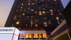 Exterior of The Starling Atlanta Midtown at dusk showing the 27-story Curio Collection tower in Colony Square