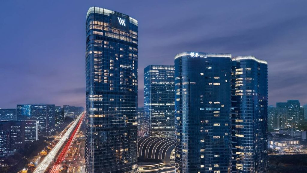 The glass towers of Waldorf Astoria Chengdu at night, with a WA sign at the top