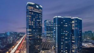 The glass towers of Waldorf Astoria Chengdu at night, with a WA sign at the top