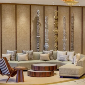 A lounge at Ka La'i Waikiki Beach with a long beige sectional sofa and patterned cushions