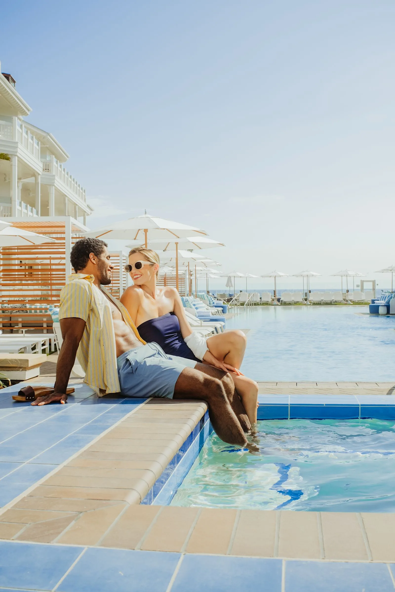 Two guests on a balcony above the pool at Shore House at The Del